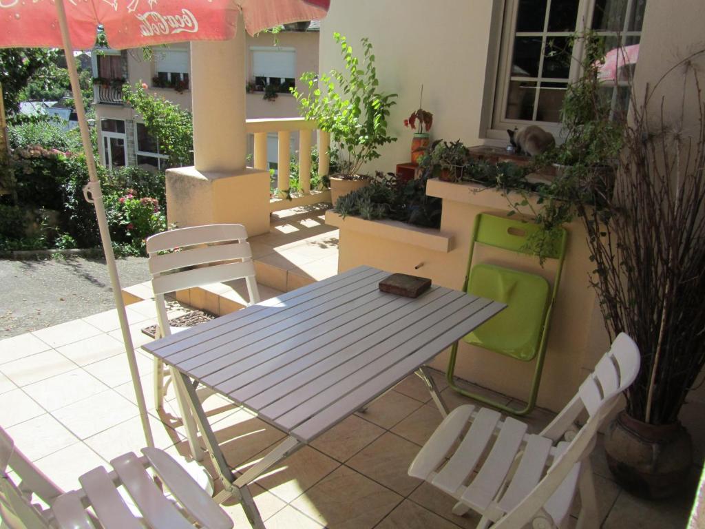 una mesa y sillas en un patio con sombrilla en Festiane, en Decazeville