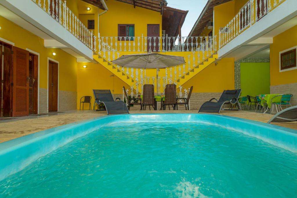 uma piscina numa casa com cadeiras e uma mesa em Pousada Príncipe dos Mares em Paraty