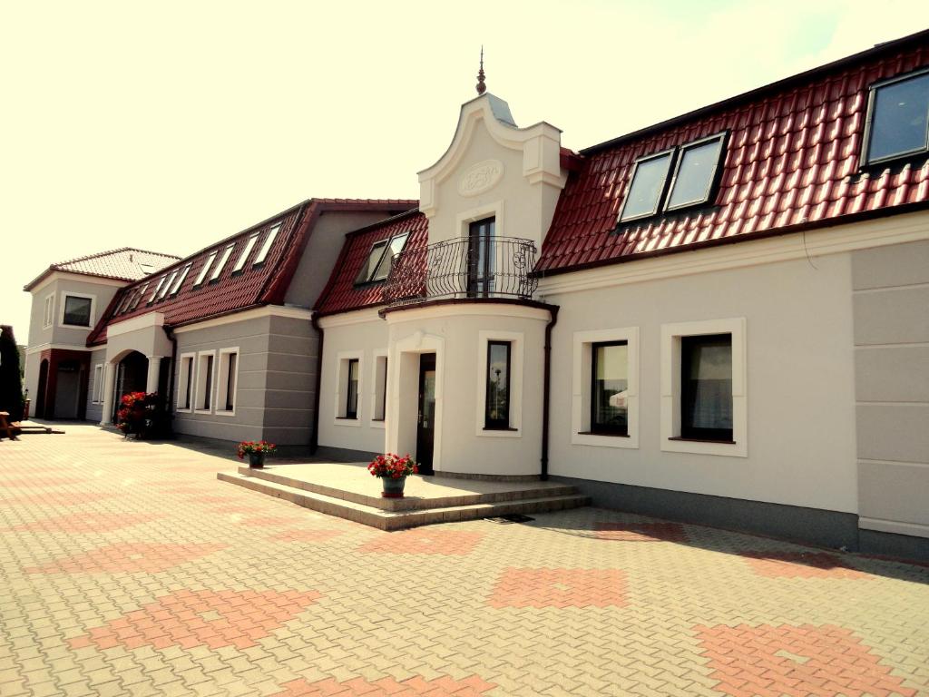 un gran edificio blanco con techo rojo en Hotel Wielkopolanka, en Środa Wielkopolska