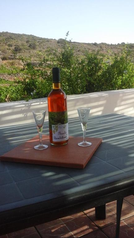 uma garrafa de uísque e dois copos numa mesa em La Palma em Pantelleria