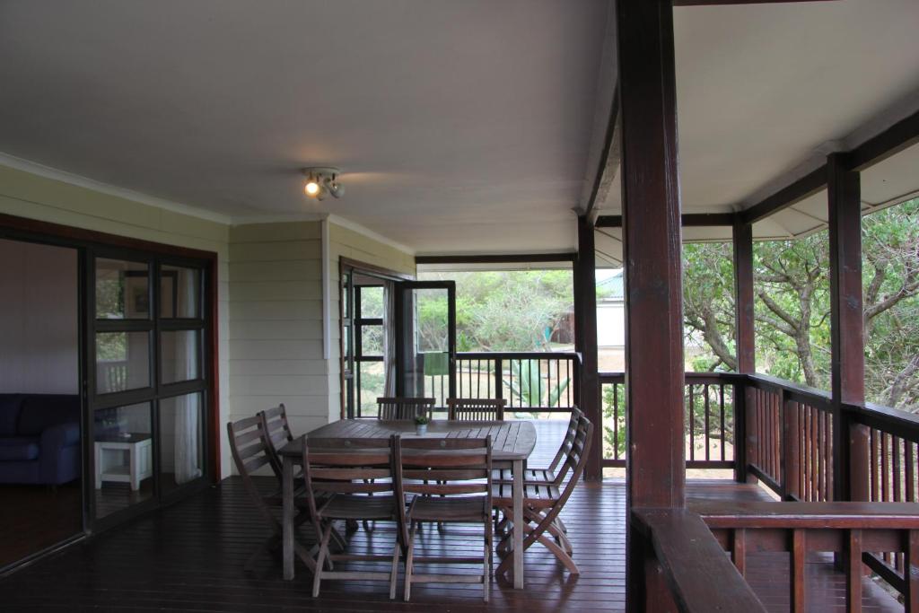 a dining room with a table and chairs on a porch at Alfies House in Ponta Malongane