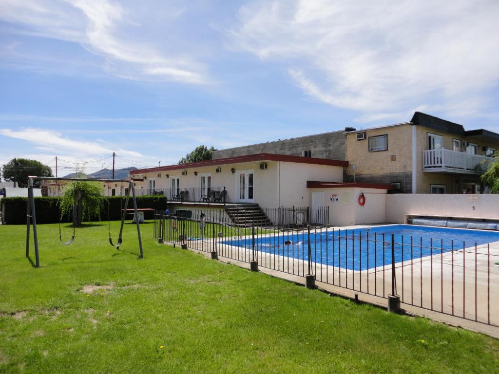 a swimming pool in a yard next to a house at Falcon Resort in Osoyoos