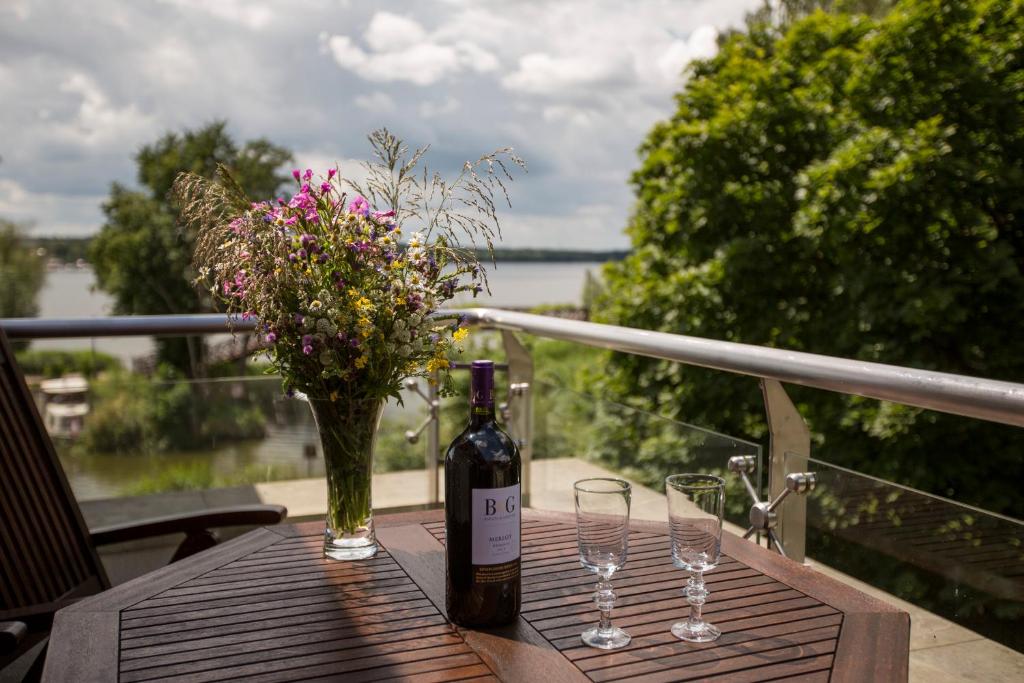a bottle of wine and two glasses on a table at Willa Port Rezydencje 310 in Ostróda