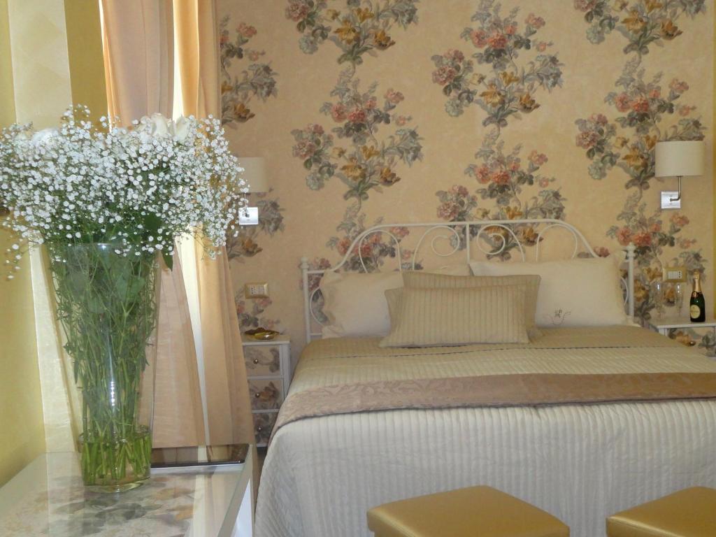 a bedroom with a bed and a vase of flowers at Cameo B&B in Rome