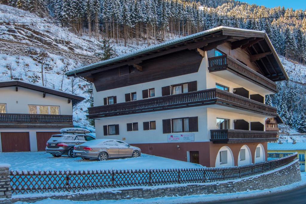 a building with a car parked in a parking lot at Landhaus St Georg by AlpenTravel in Bad Gastein