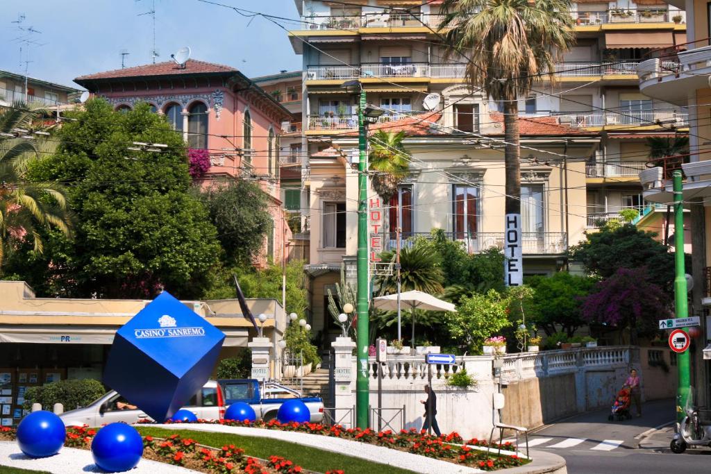 einen blauen Regenschirm in einem Garten vor einem Gebäude in der Unterkunft Hotel Liberty in Sanremo