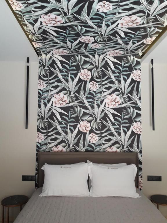 a bedroom with a floral patterned wall above a bed at 4 Seasons Luxury Apartments in Alexandroupoli