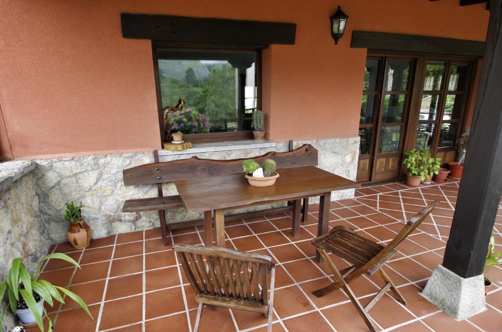 eine Terrasse mit einem Tisch und Stühlen auf einem Fliesenboden in der Unterkunft Hotel Rural Porrua in Porrúa