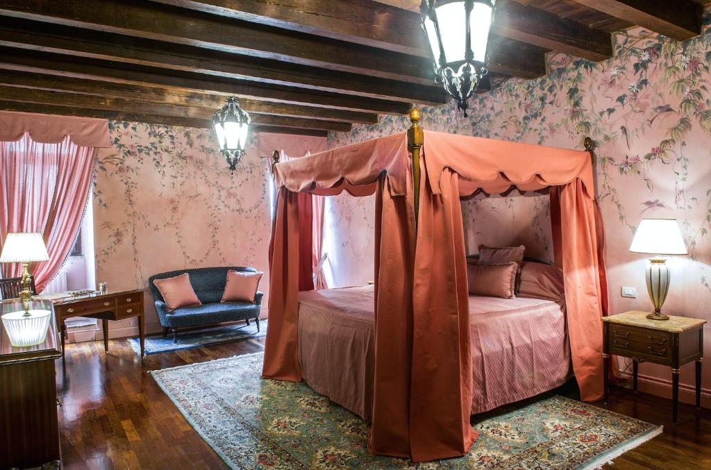 sypialnia z łóżkiem z baldachimem i krzesłem w obiekcie Casa Borsari Suite w Weronie