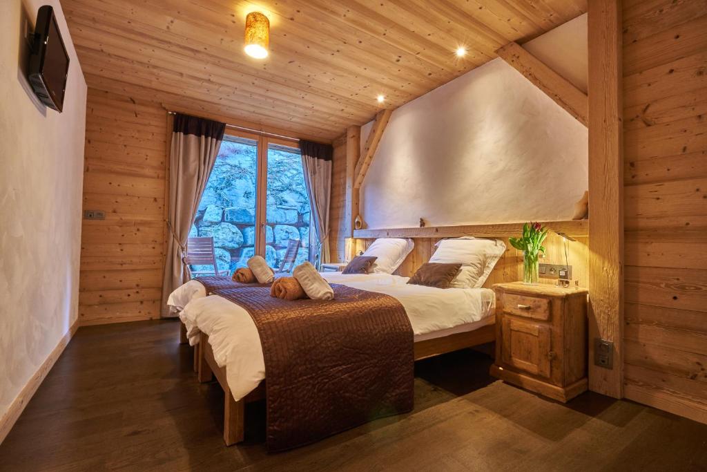 a bedroom with two beds and a window at Chalet Virolet in Les Gets
