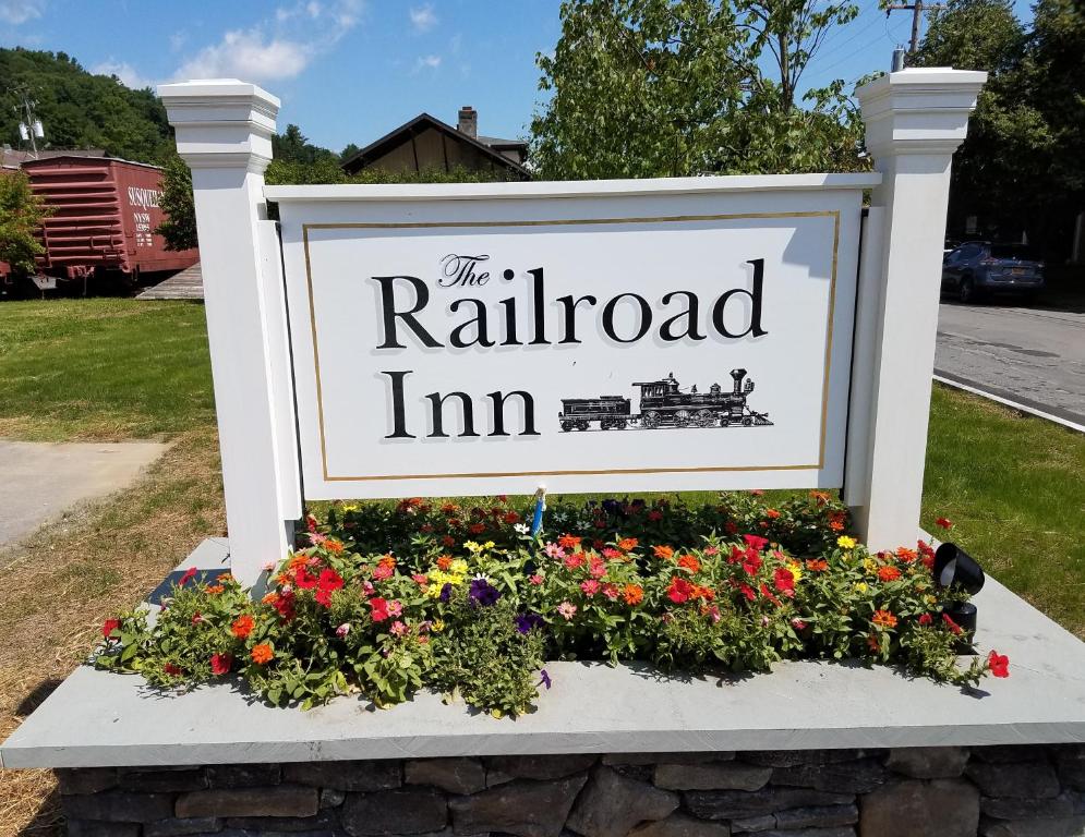 un panneau indiquant l'auberge de chemin de fer avec des fleurs dans l'établissement The Railroad Inn, à Cooperstown