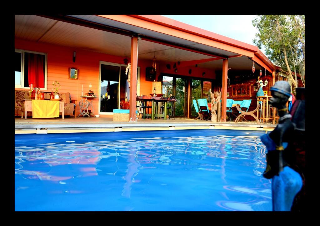 uma piscina em frente a uma casa em Gîte et meublés du Tour du monde em Dumbéa