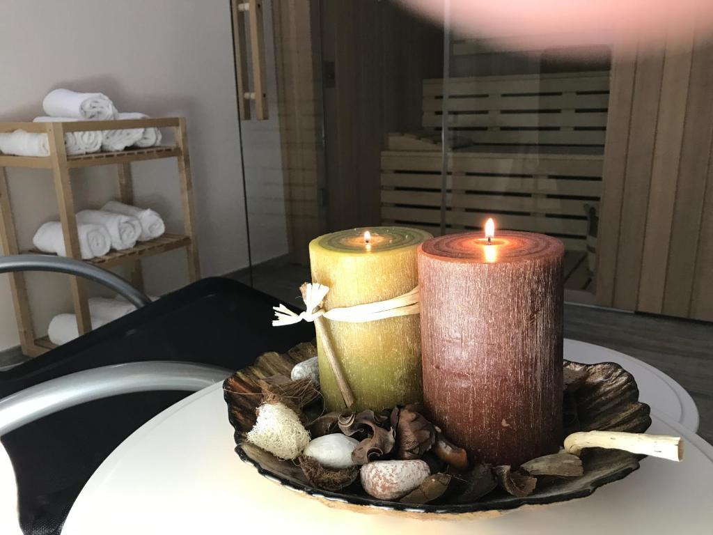 duas velas em cima de uma mesa com conchas em Hotel Miramonti em Sestola