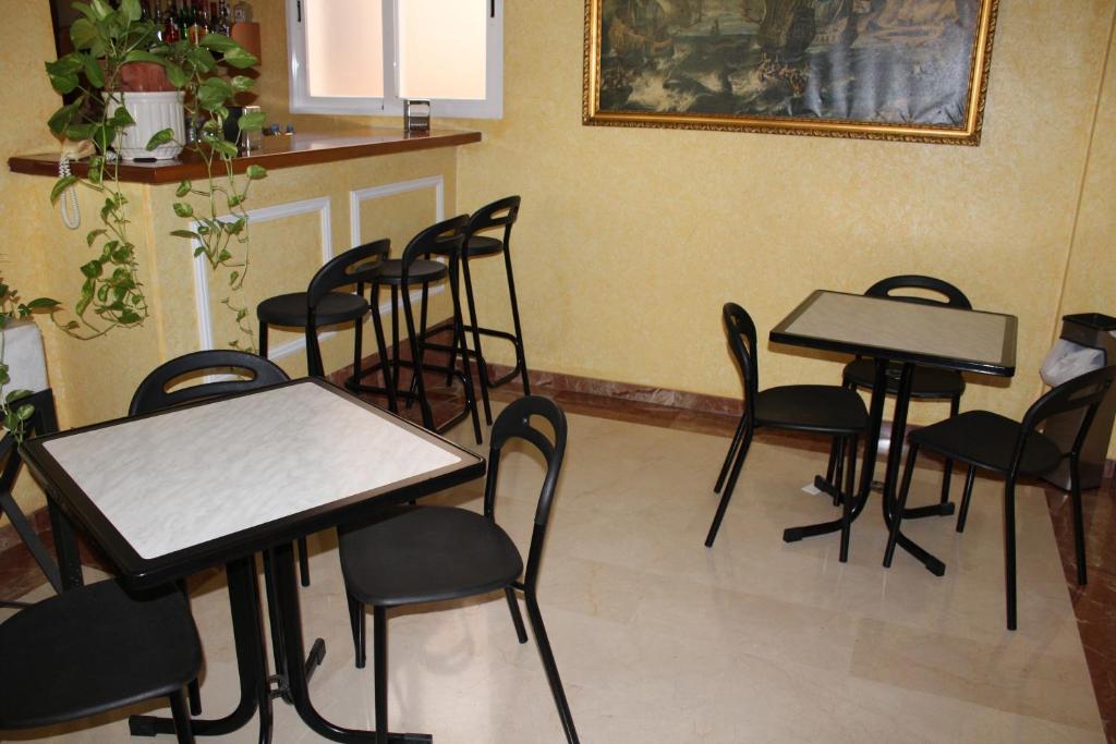 un grupo de mesas y sillas en una habitación en Hotel Albohera, en Santiago de la Ribera