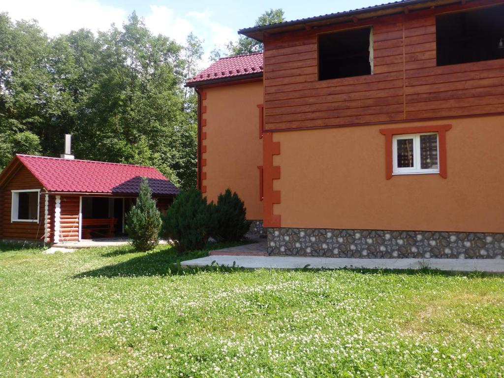 a house with a red roof and a yard at Kreitser in Lazeshchyna