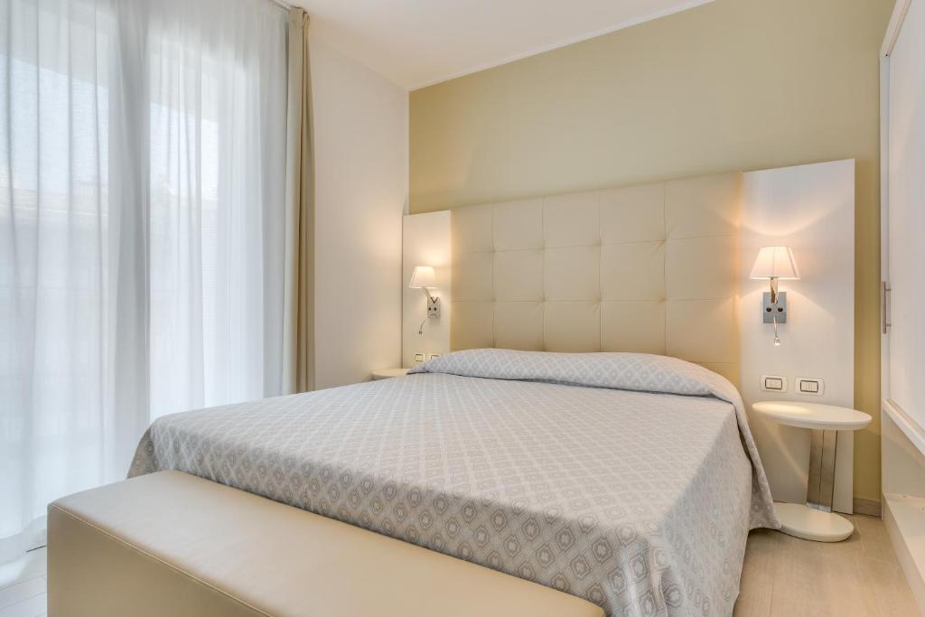 a bedroom with a white bed and a window at Hotel Ambassador in Caorle