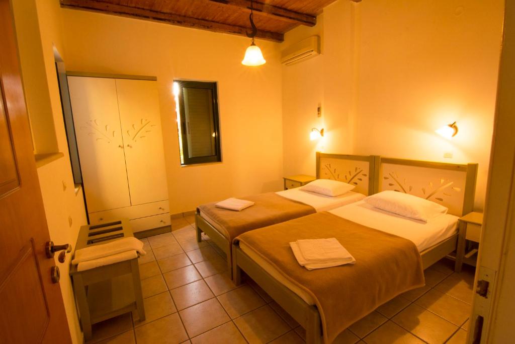 パレオコラにあるVillas Paleochoraのベッド2台とバスルームが備わるホテルルームです。