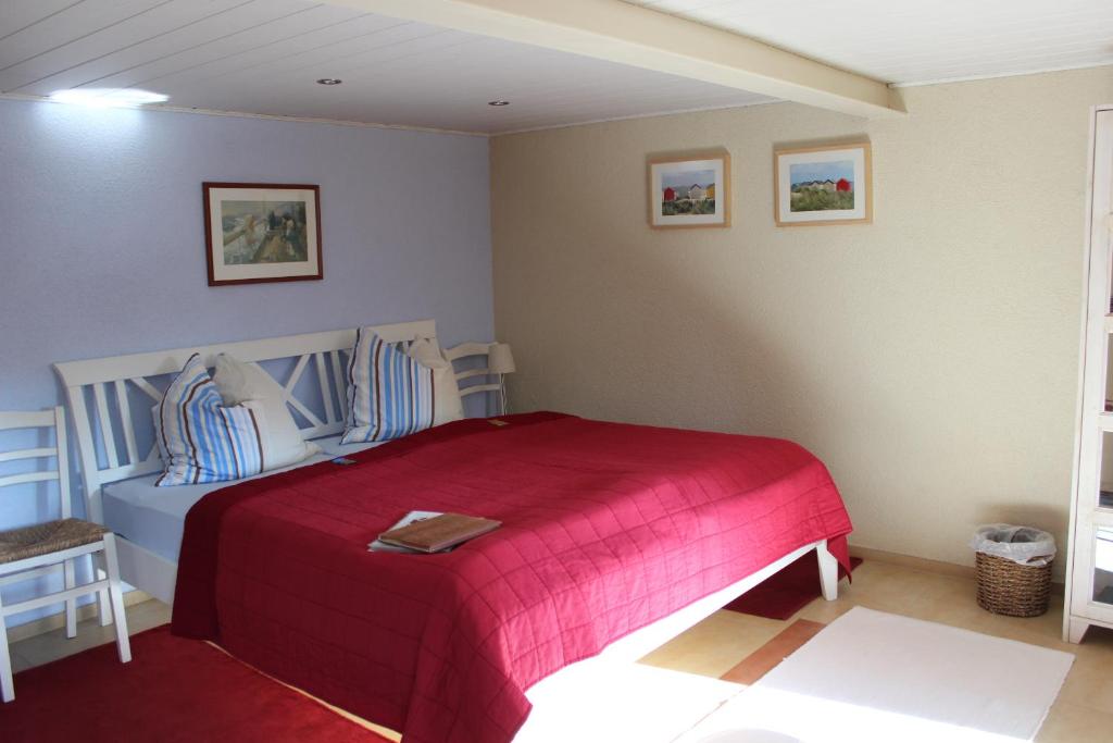 a bedroom with a bed with a red blanket at Fahrradpension am Weg nach Kopenhagen in Fürstenberg-Havel