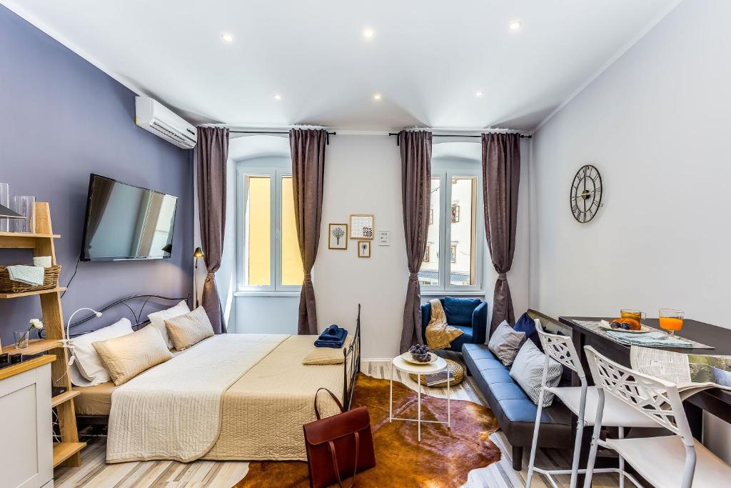 a bedroom with a bed and a living room at Main Square studios in Rijeka