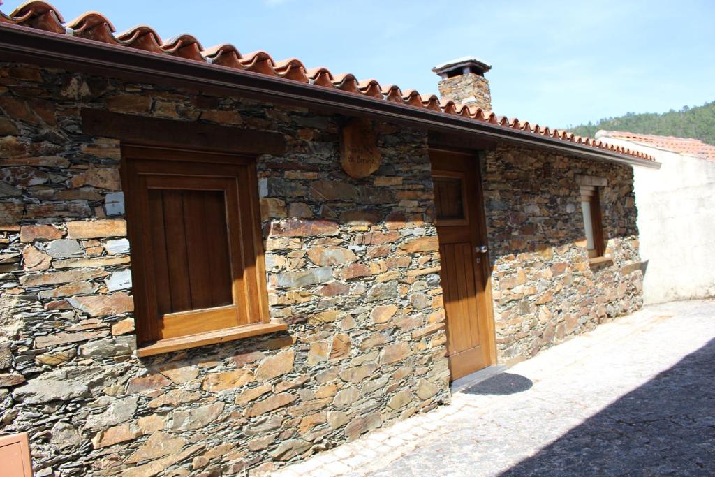 un edificio de piedra con una puerta de madera. en Casa da Comareira, en Góis