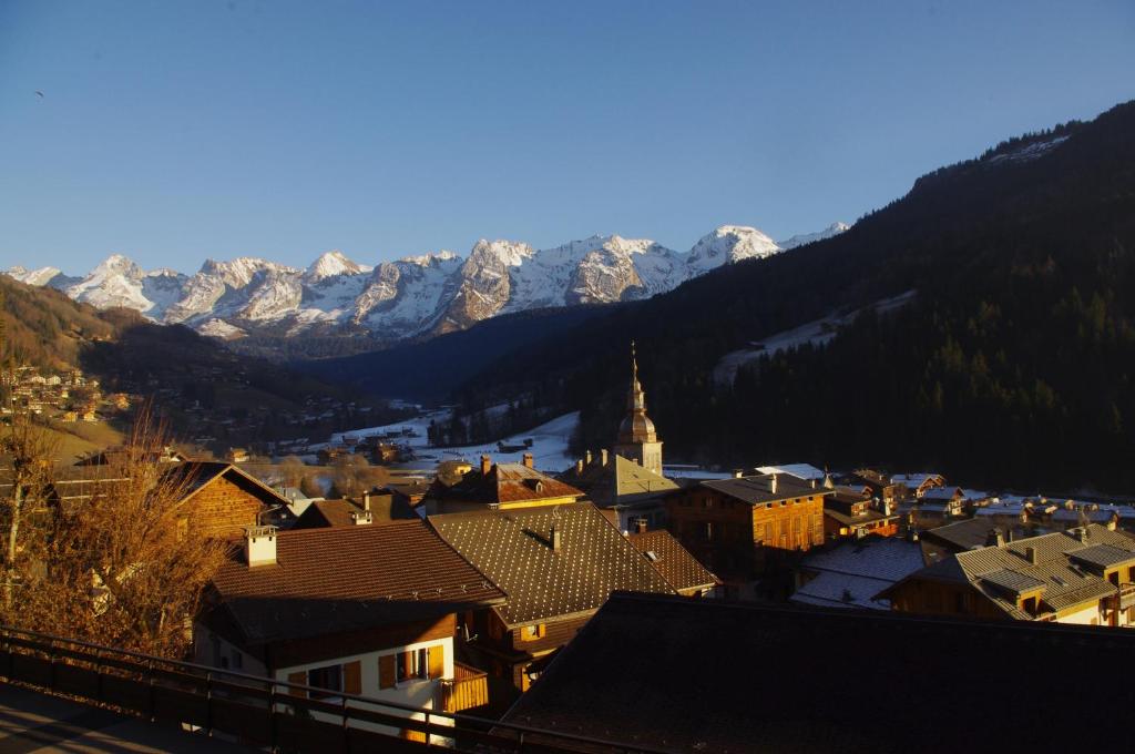 a small town with snow covered mountains in the background at Studio Beauregard in Le Grand-Bornand