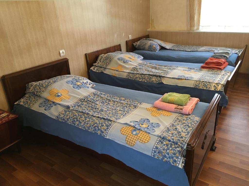 um grupo de três camas num quarto em Guest House GarniResthost em Garni