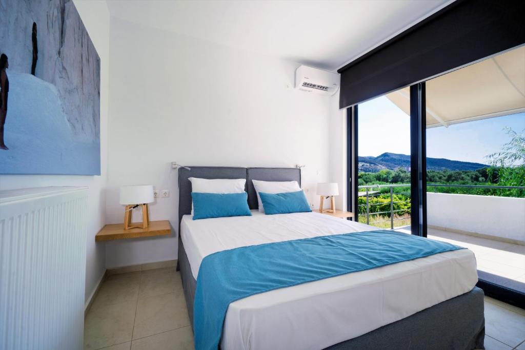 a bedroom with a bed and a large window at Seametry Luxury Living Villa in Chania