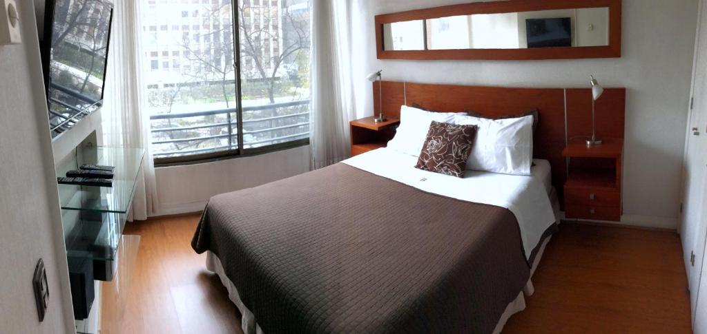 a bedroom with a bed and a large window at Brizen Apartments in Santiago