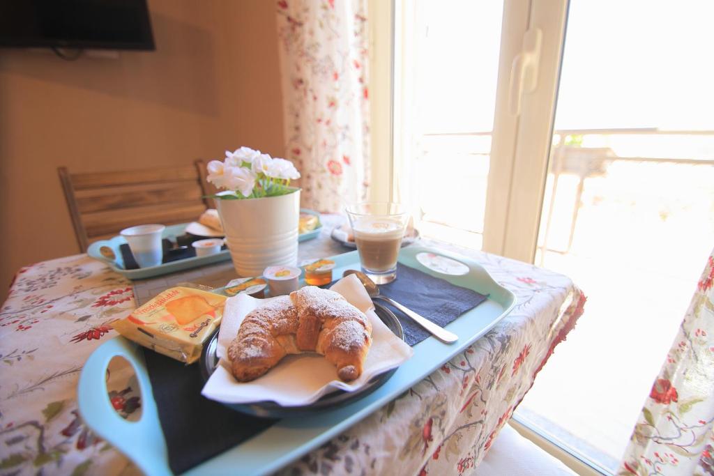 una mesa con una bandeja con pan y bollería. en Gioeni ventidue en Agrigento