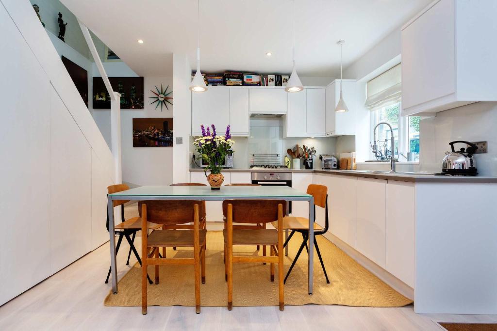 a kitchen with a table and chairs and a counter at Veeve - Camden Mews Terrace in London