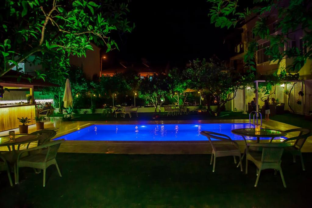 una piscina por la noche con mesas y sillas en Grandma's Garden en Dalyan