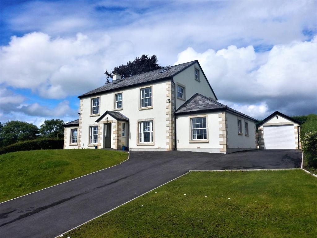 a large white house on a hill with a driveway at Ghyll Beck House bed and breakfast in Leck