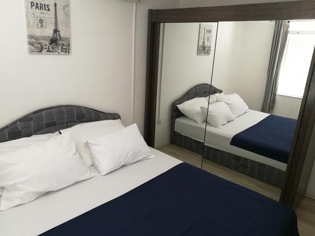 a bedroom with two beds and a mirror at Apartments Matas in Rogoznica