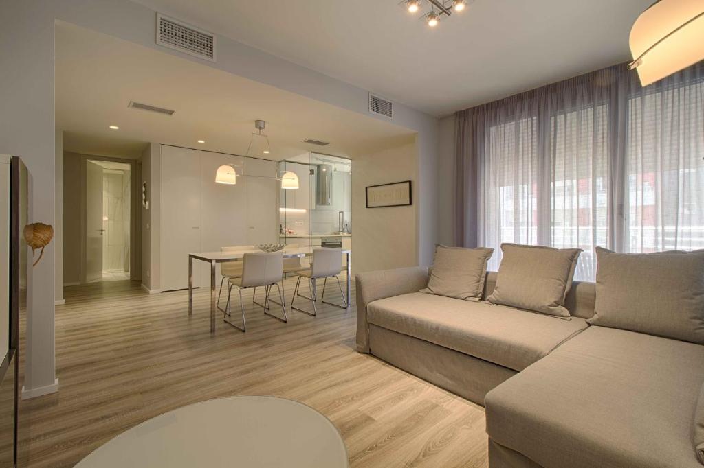 The Rooms Serviced Apartments Nobis Complex في تيرانا: غرفة معيشة مع أريكة وطاولة
