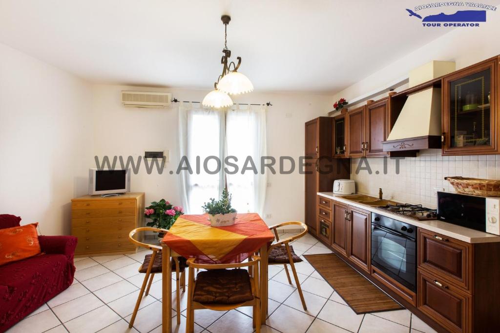 a living room with a table and a kitchen at Case Vacanza Aiosardegna in Pula
