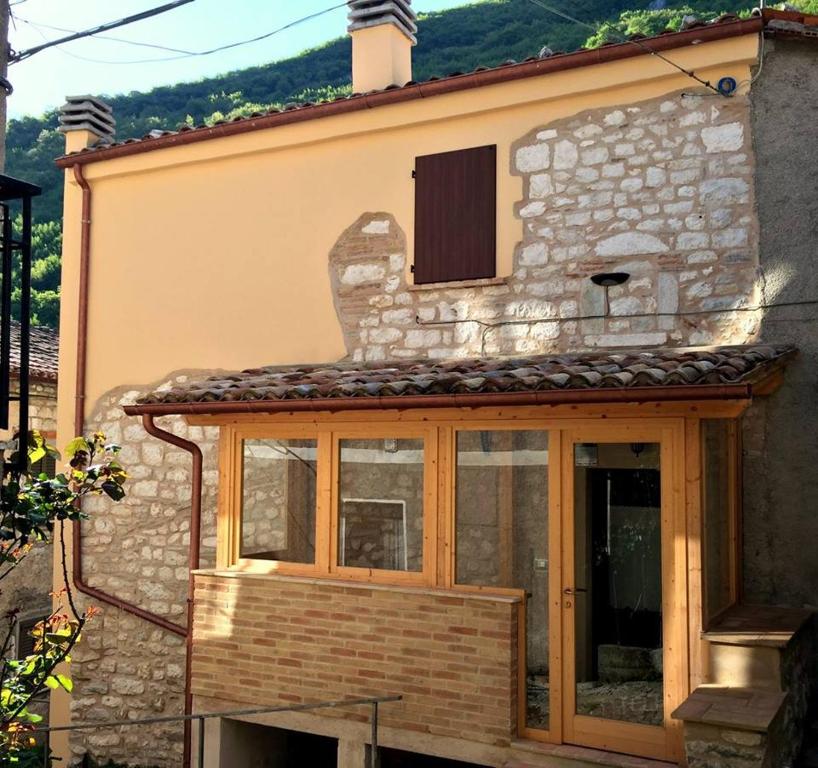 una casa con una ventana en un lado en Casa Vacanze L'arco di Fondarca, en Cagli