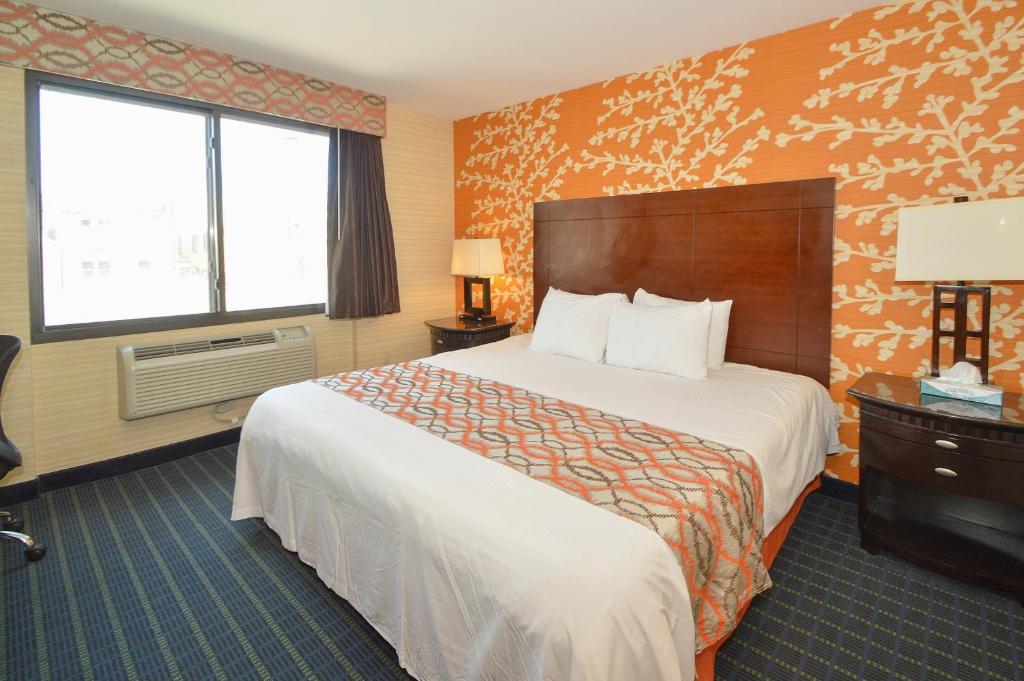 a hotel room with a large bed and a large window at Corona Hotel New York - LaGuardia Airport in Queens