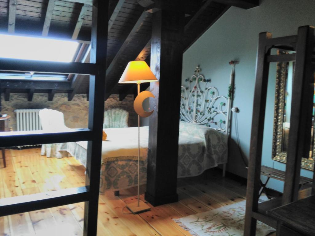 a bedroom with a bed and a lamp in a room at Casona Camino de Hoz in Anero