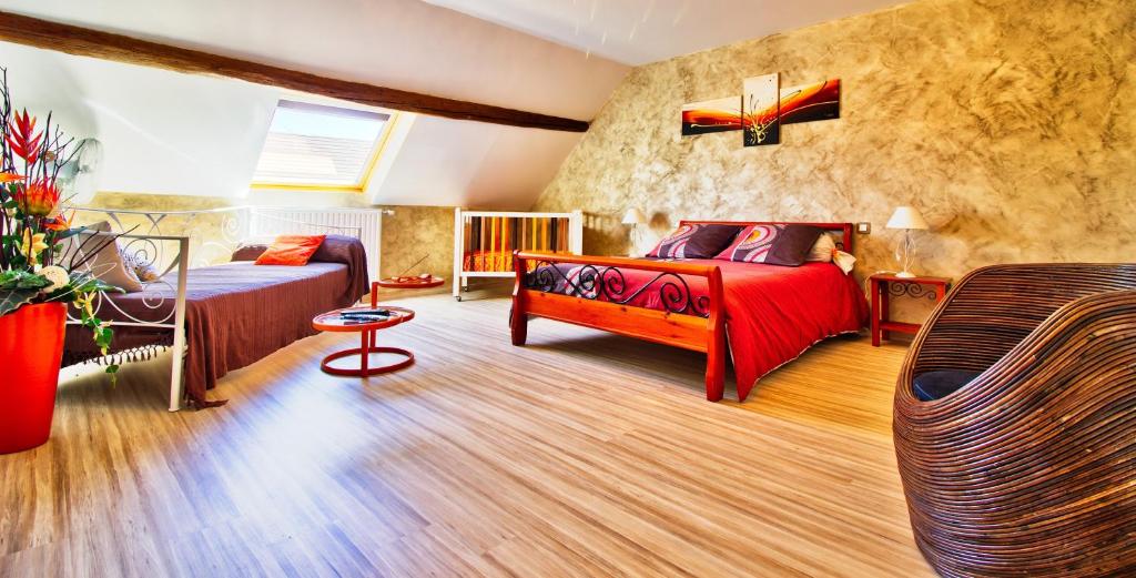 um quarto com 2 camas e um sofá em chambres d'hôte Le Marronnier em Champrougier