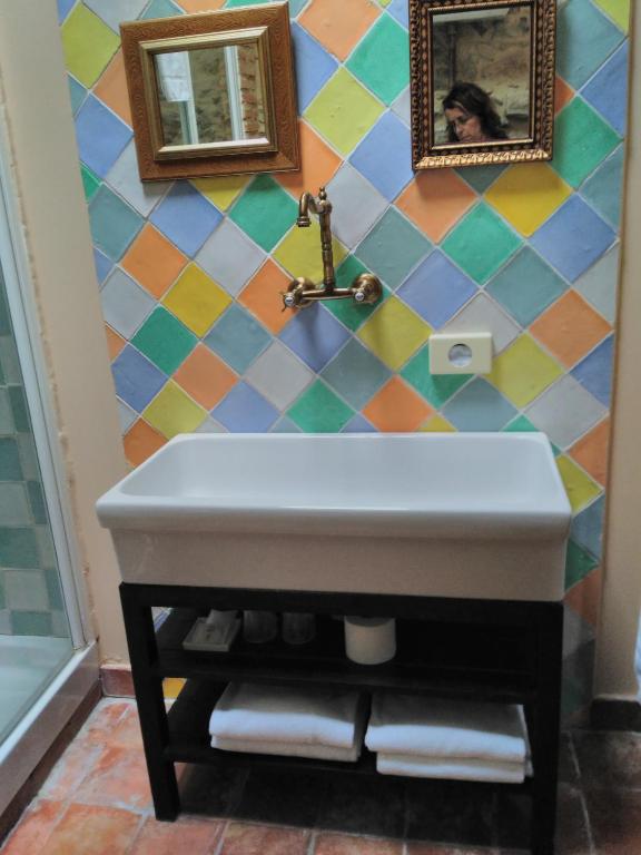 a bathroom with a sink and a colorful wall at Casona Camino de Hoz in Anero