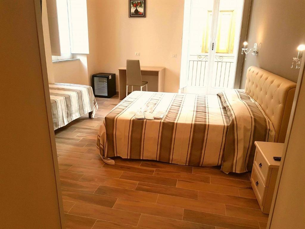 um quarto com 2 camas e piso em madeira em B&B The Tower em Tropea