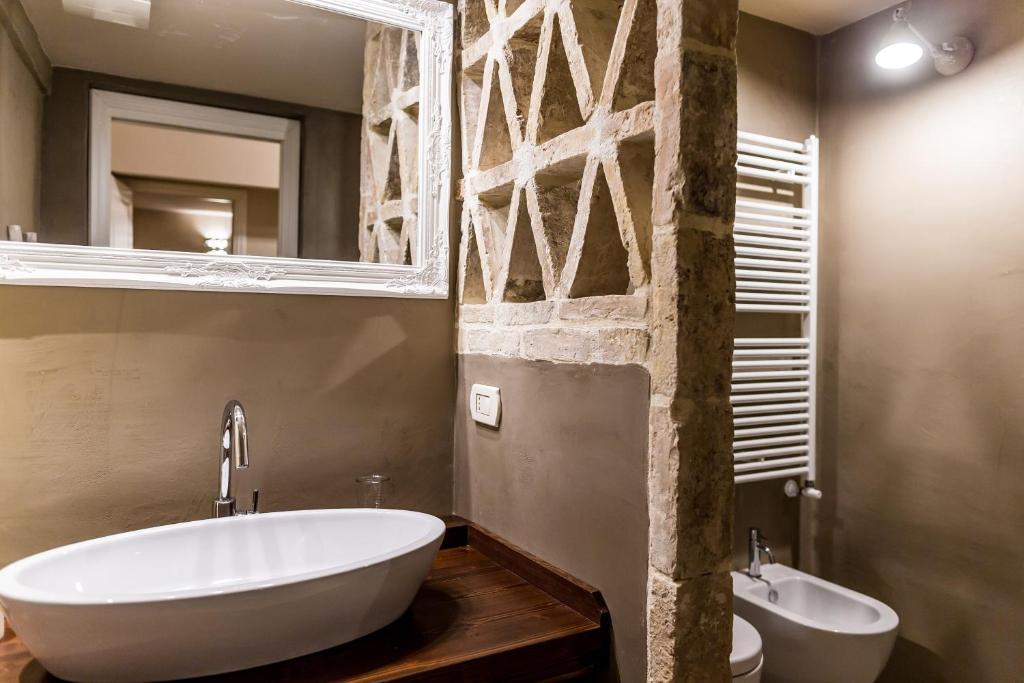 a bathroom with a tub and a sink and a mirror at Borgo San Gaetano in Bernalda