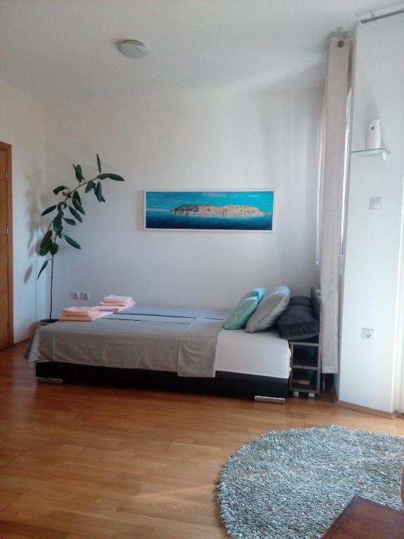 ein Schlafzimmer mit einem Bett und einem Gemälde an der Wand in der Unterkunft Apartment Boris in Niš