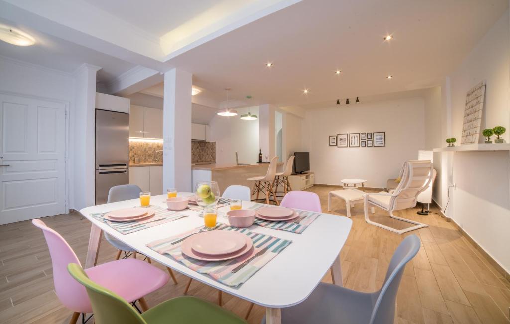 a kitchen and dining room with a white table and chairs at Zante Deco Apartment in Zakynthos Town