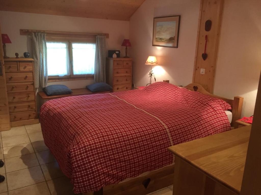 a bedroom with a red bed and a window at Chalet les Chouettes in Thônes