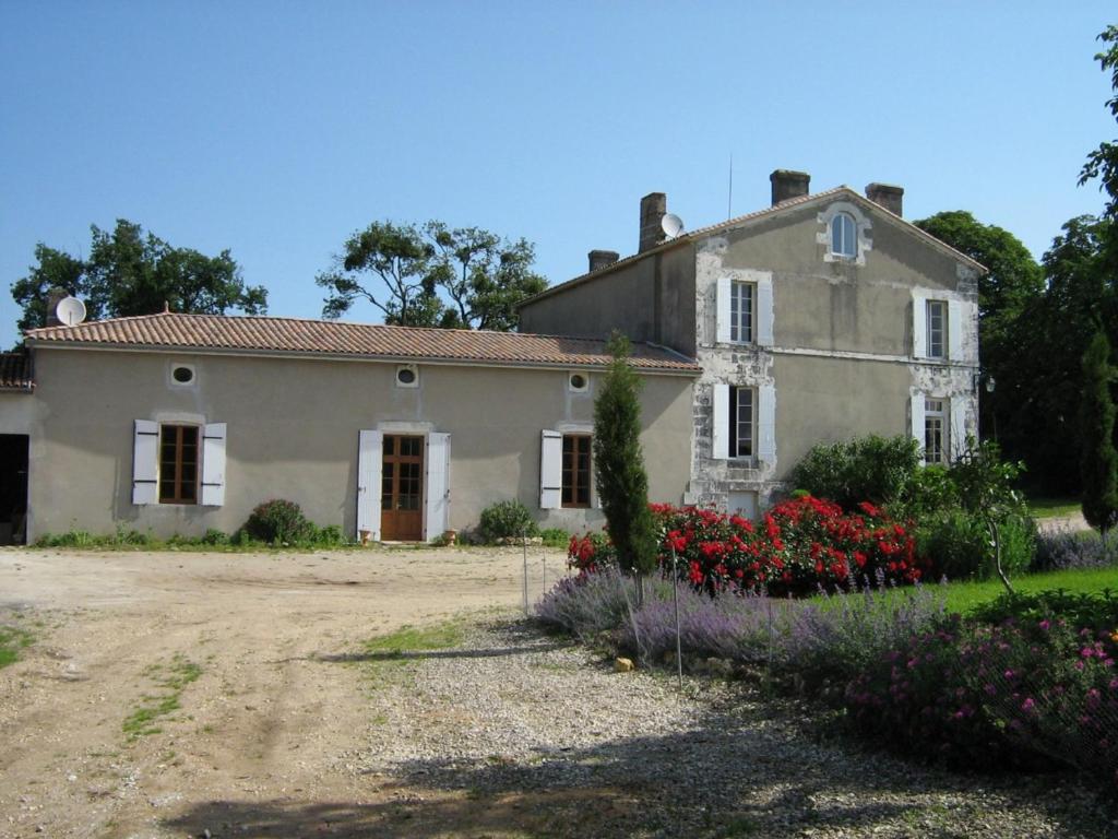 an old house with flowers in front of it at Domaine les Galards in Le Garde