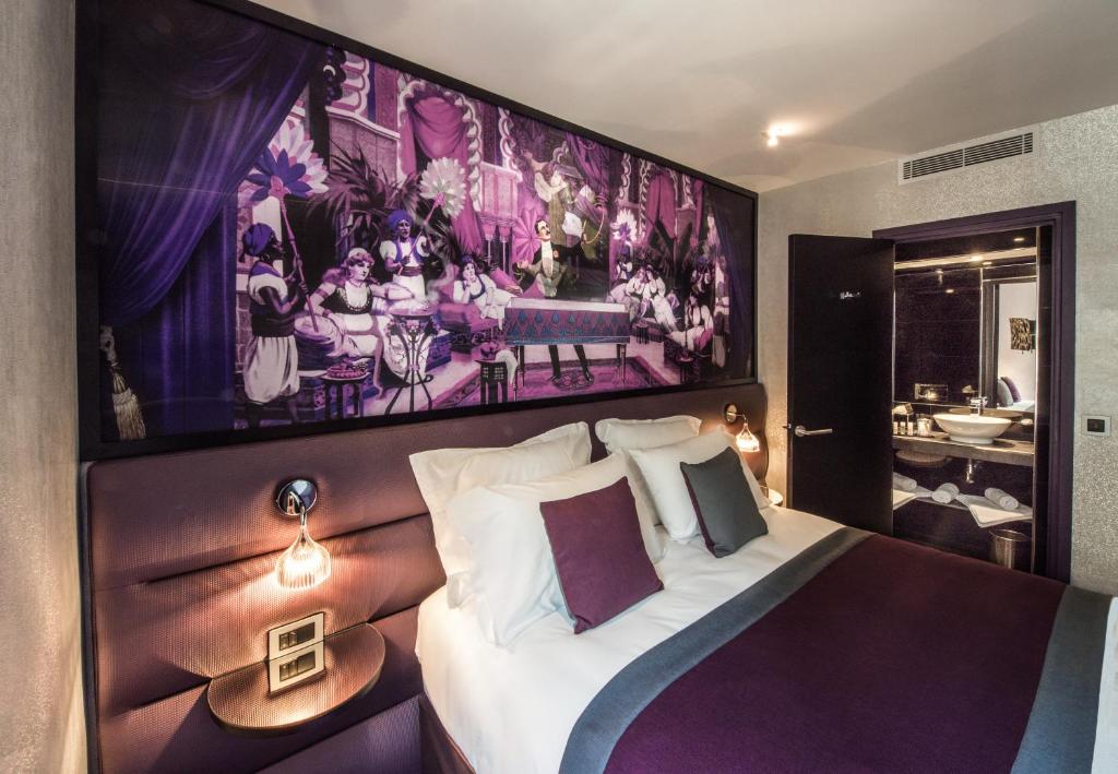 a bedroom with a large painting above a bed at Hotel Splendor Elysées in Paris