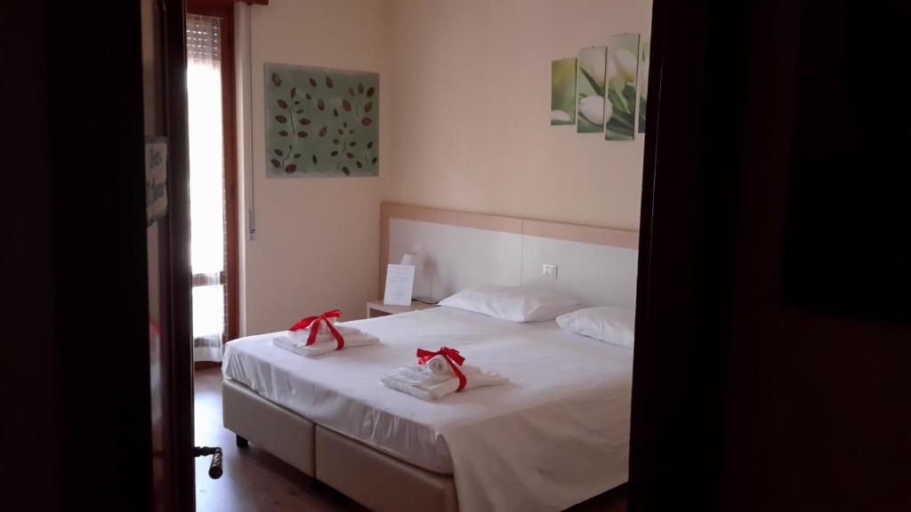 a bedroom with a white bed with red bows on it at B&B Il Mondo Di Ross in Verona