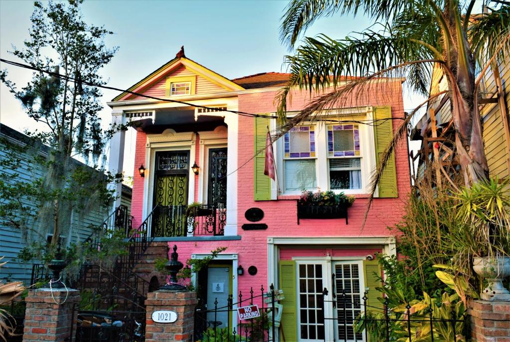 a pink and yellow house with a balcony at Madame Isabelle's House in New Orleans