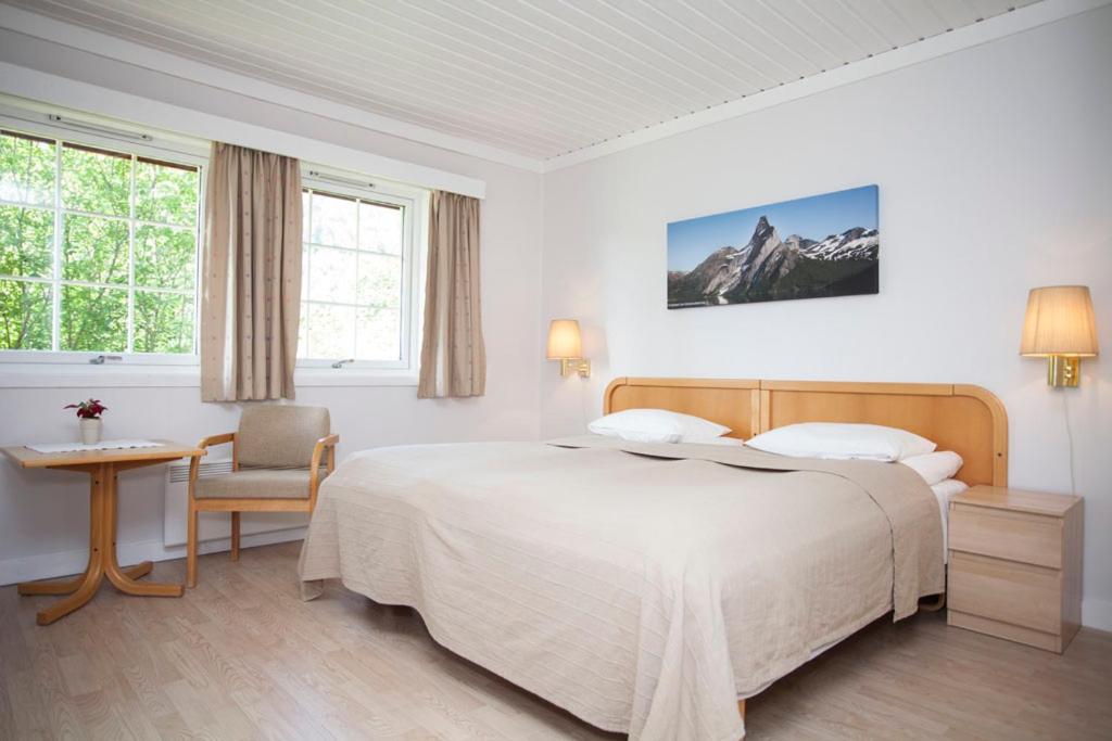 um quarto com uma cama, uma mesa e uma cadeira em Stetind Hotel em Kjøpsvik